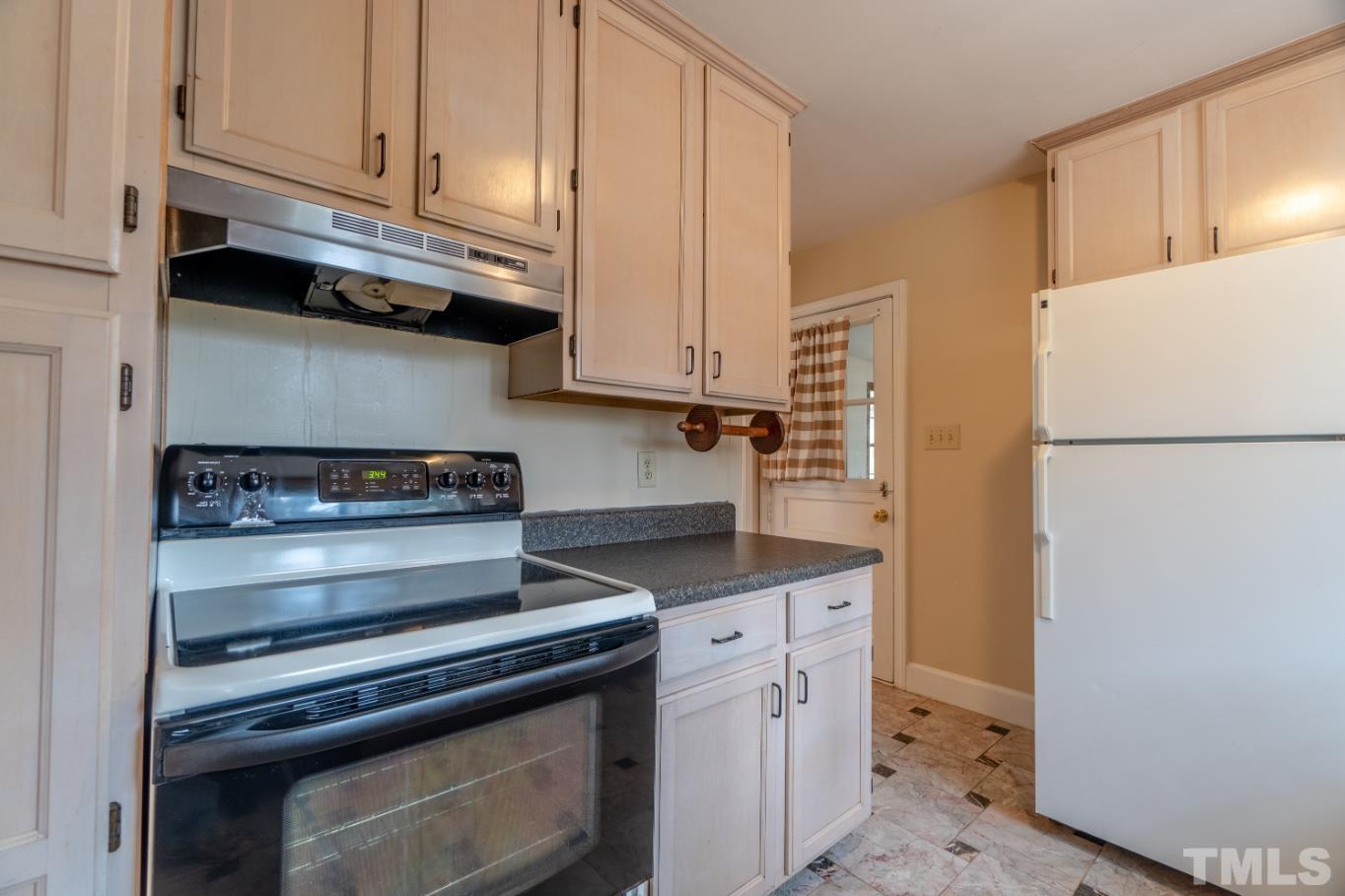 2 Maple Drive Chapel Hill, NC 27514 - Photo 36 of 57 a kitchen with granite countertop a refrigerator stove and white cabinets