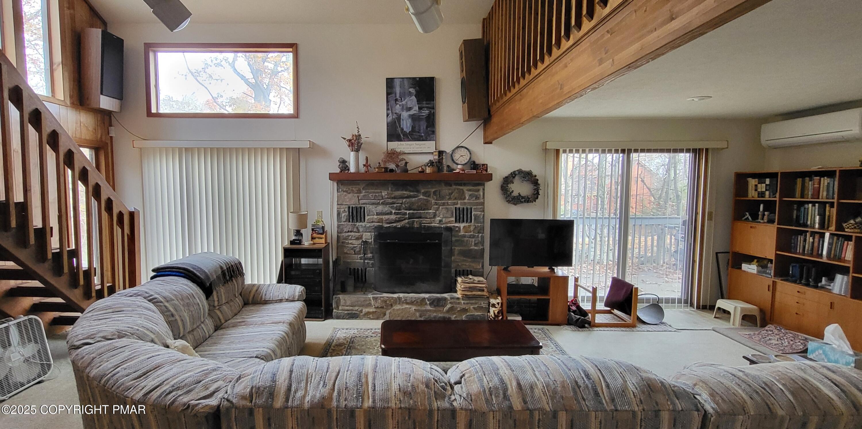 130 Bellingham Drive Bushkill, PA 18324 - Photo 14 of 65 a living room with furniture a fireplace and a book shelf