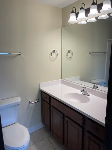 a bathroom with a sink a toilet and mirror