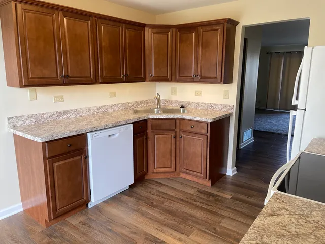 a kitchen with stainless steel appliances granite countertop wooden cabinets a sink and dishwasher