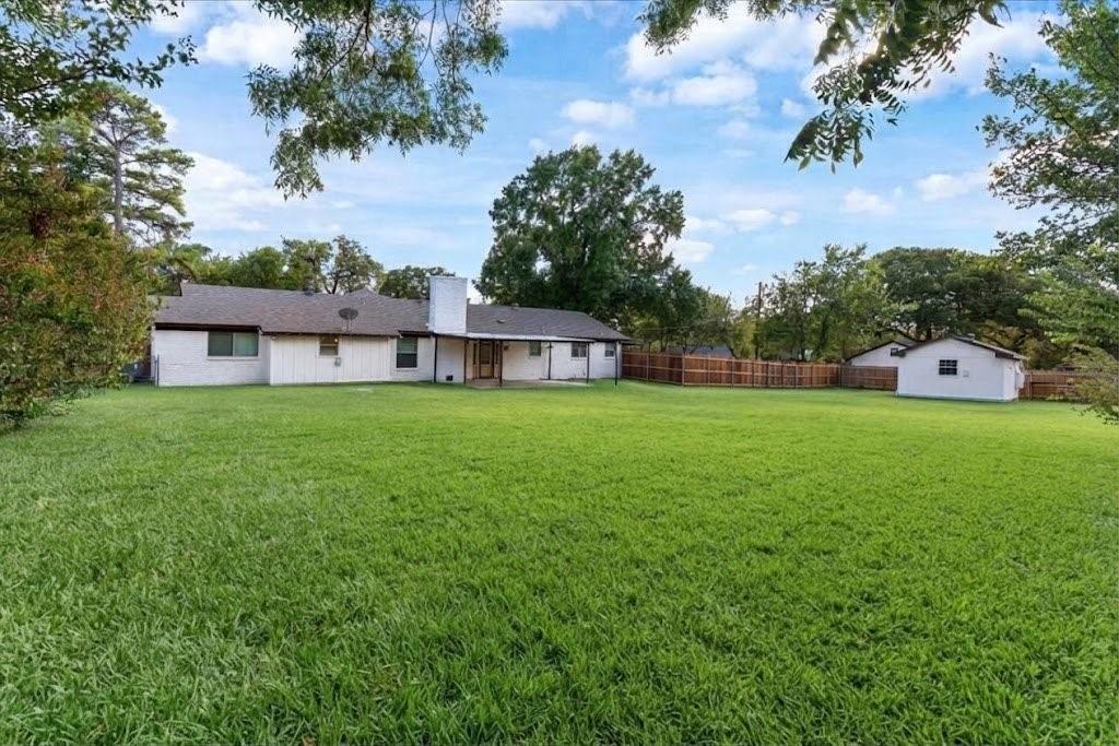 3509 West Sublett Road Arlington, TX 76017 - Photo 37 of 39 Expansive backyard featuring a manicured lawn, established trees, a covered patio, and a detached structure