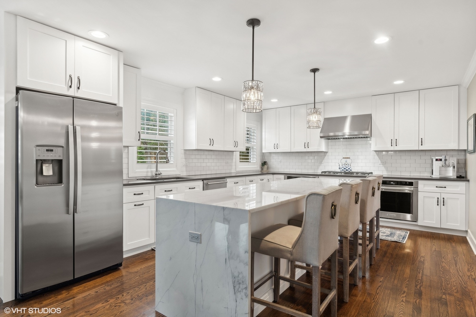 87 Ridge Road Highland Park, IL 60035 - Photo 6 of 27 a kitchen with stainless steel appliances granite countertop a refrigerator a sink a stove a kitchen island and chairs with wooden floor