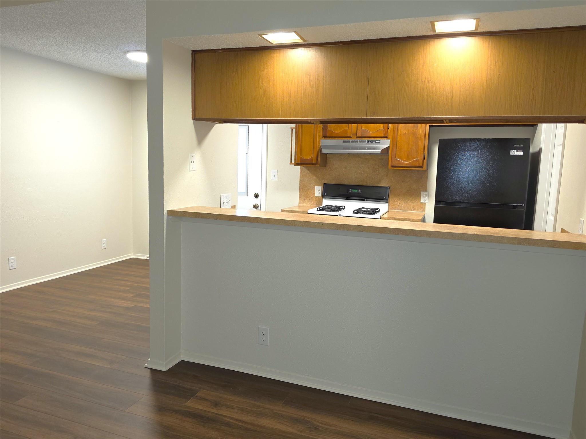11314 Walnut Ridge Drive, Unit B Austin, TX 78753 - Photo 3 of 20 A functional kitchen with wood-look flooring and an efficient pass-through design.