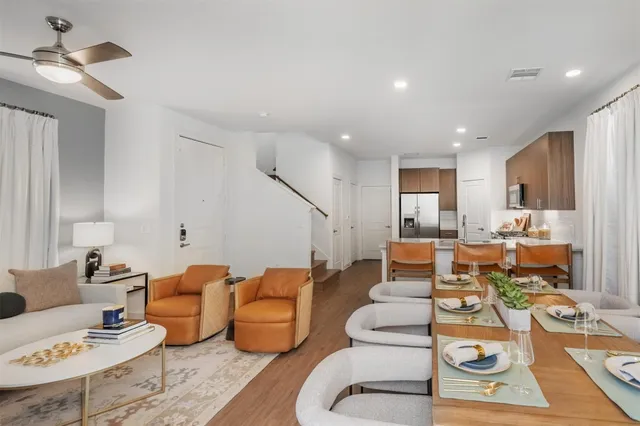 a living room with furniture kitchen view and a chandelier