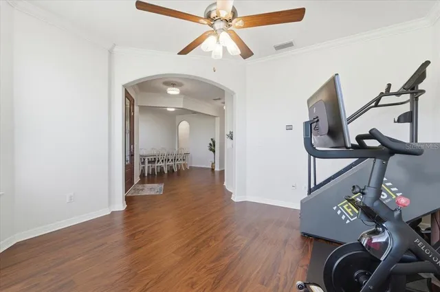 a view of a room with wooden floor windows and a chandelier fan