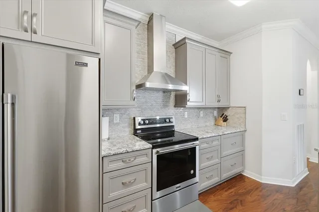 a kitchen with stainless steel appliances granite countertop a stove a refrigerator and a white cabinets