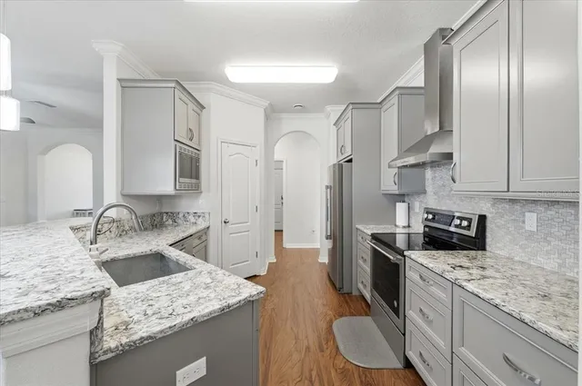 a kitchen with stainless steel appliances granite countertop a sink stove and refrigerator