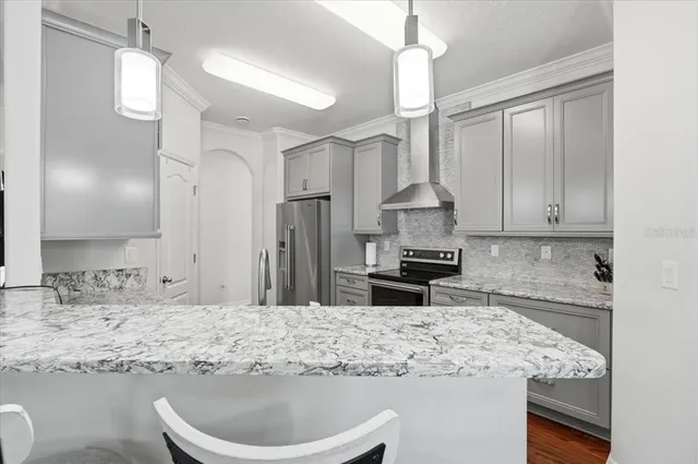 a kitchen with stainless steel appliances granite countertop a stove a sink and a refrigerator