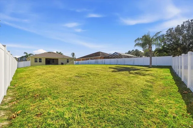 an aerial view of a tennis ground and a cars park side of the road
