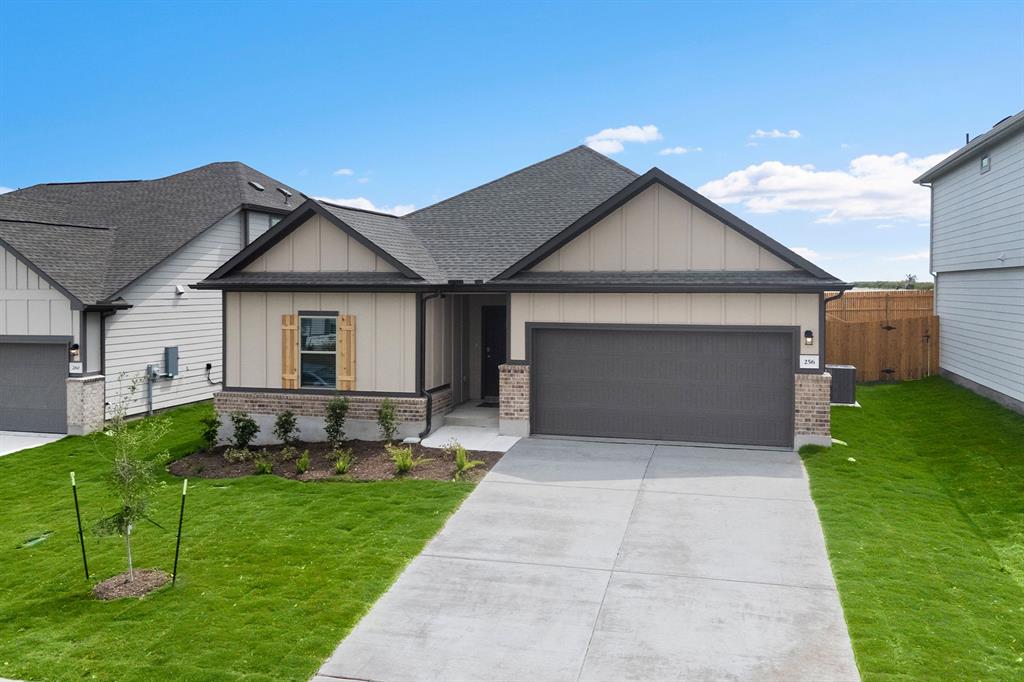 View of front of house with board and batten siding, brick siding, and a shingled roof