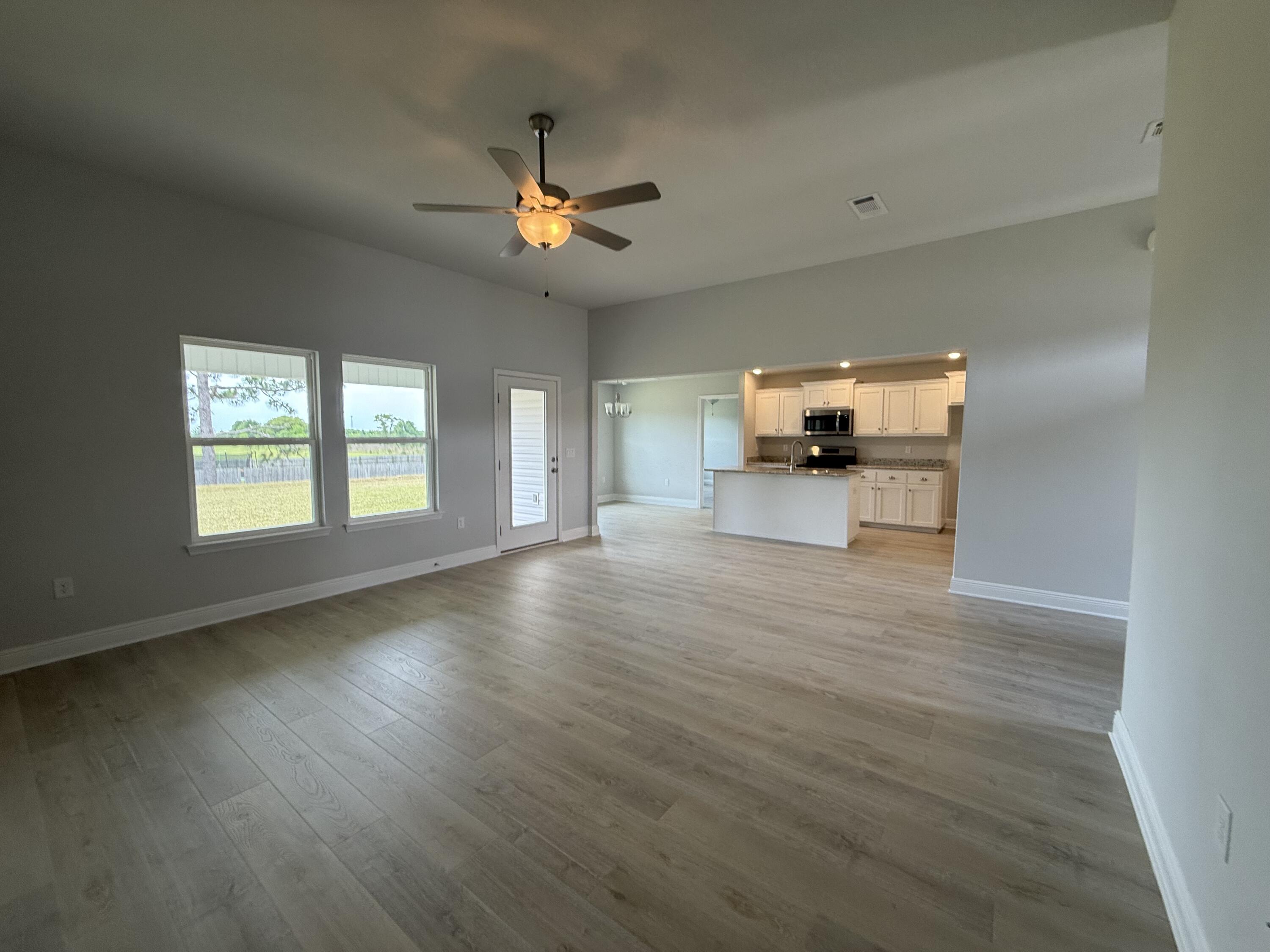 6002 Crocket Cove Crestview, FL 32539 - Photo 14 of 29 a view of empty room with wooden floor and fan