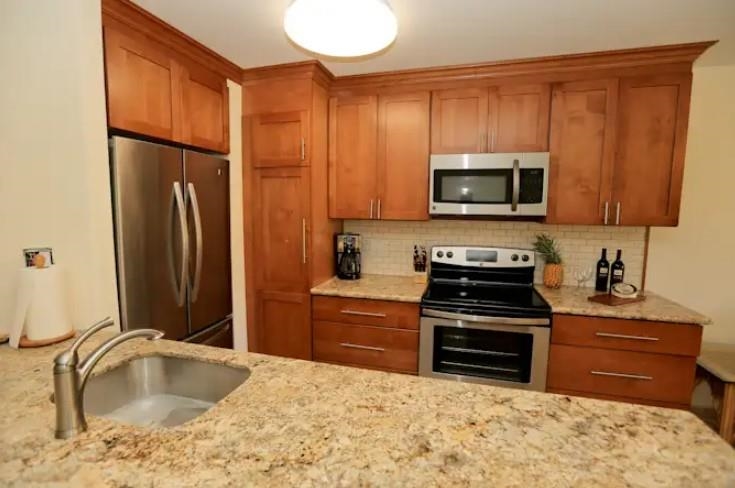 1032 South Kihei Road, Unit A103 Kihei, HI 96753 - Photo 11 of 48 a kitchen with stainless steel appliances granite countertop a refrigerator stove and sink