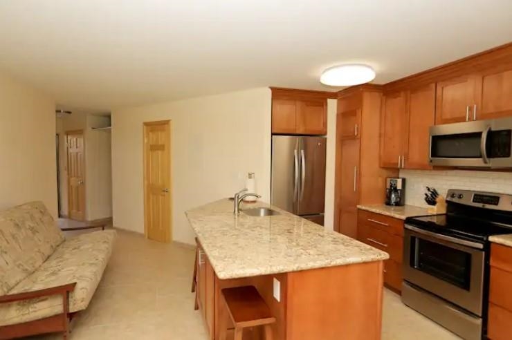 1032 South Kihei Road, Unit A103 Kihei, HI 96753 - Photo 13 of 48 a kitchen with stainless steel appliances granite countertop a stove refrigerator and microwave