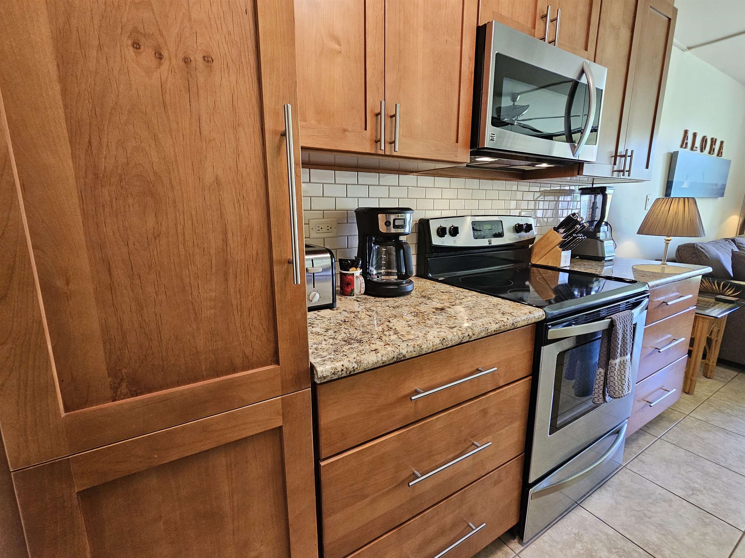 1032 South Kihei Road, Unit A103 Kihei, HI 96753 - Photo 17 of 48 a kitchen with stainless steel appliances granite countertop a stove and a microwave