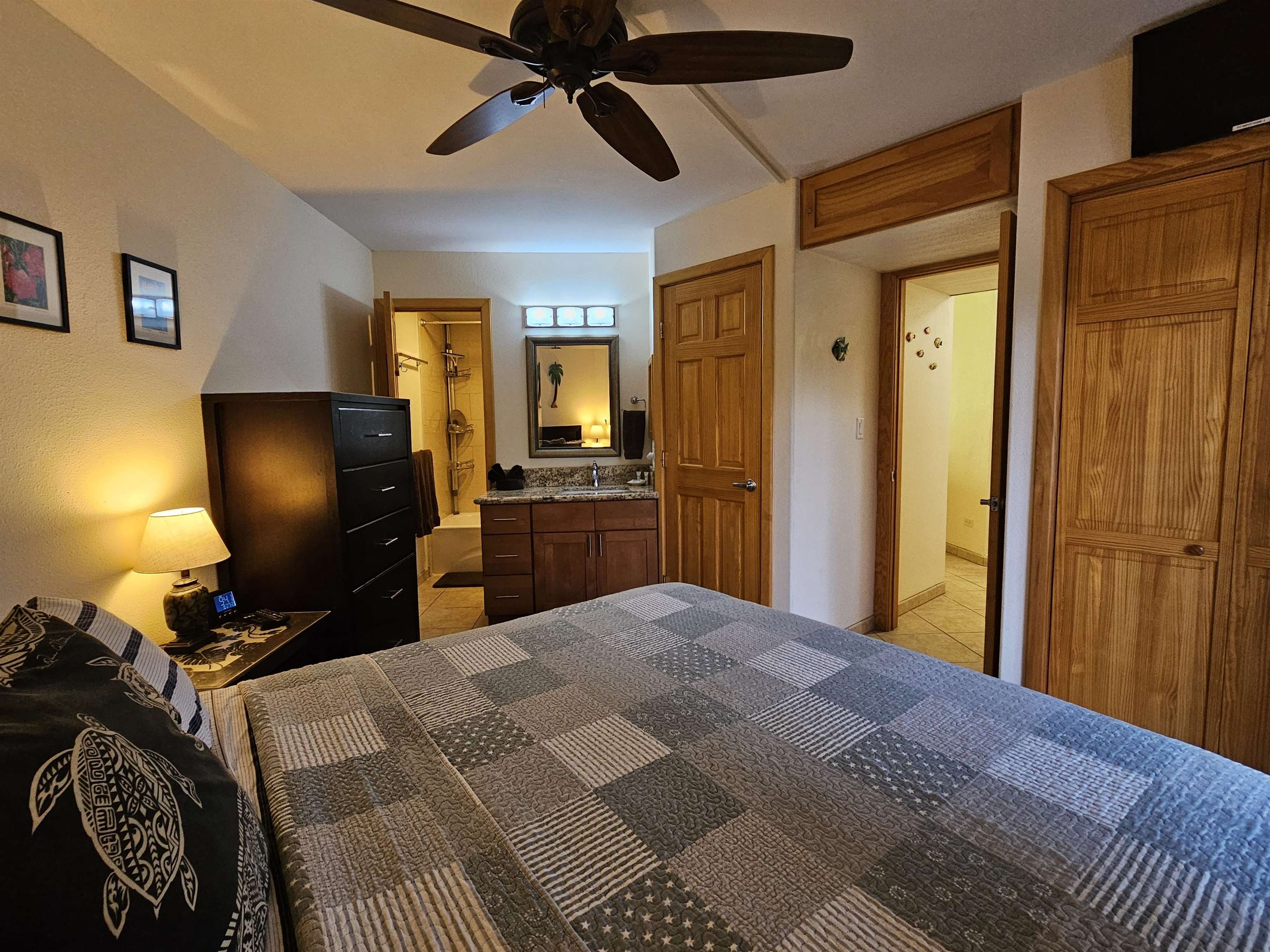 1032 South Kihei Road, Unit A103 Kihei, HI 96753 - Photo 31 of 48 a bedroom with a bed and a chandelier