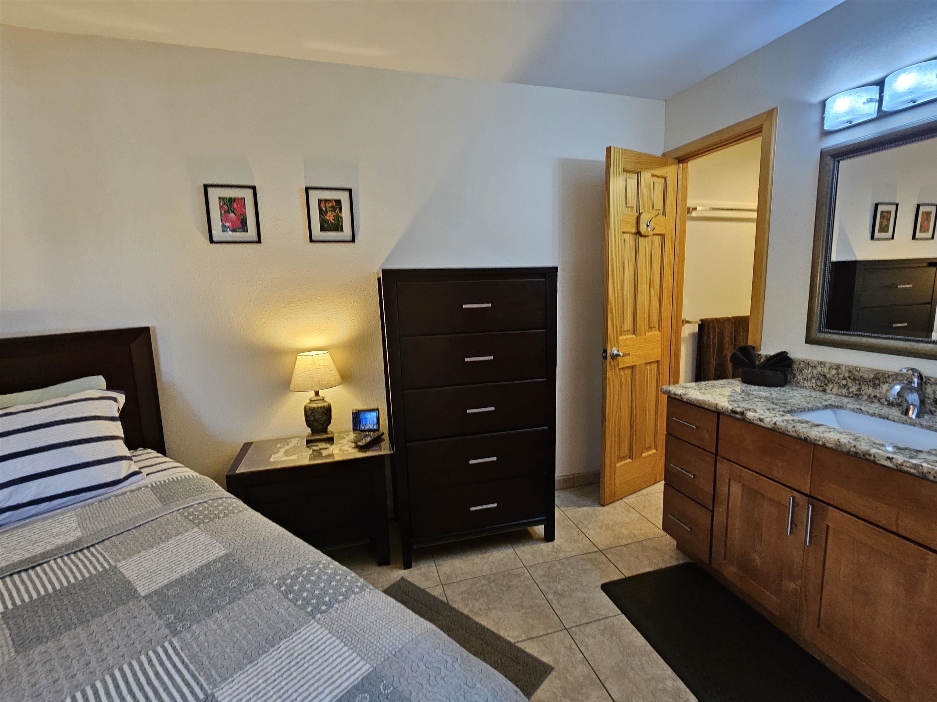 1032 South Kihei Road, Unit A103 Kihei, HI 96753 - Photo 33 of 48 a bedroom with a bed and wooden floor