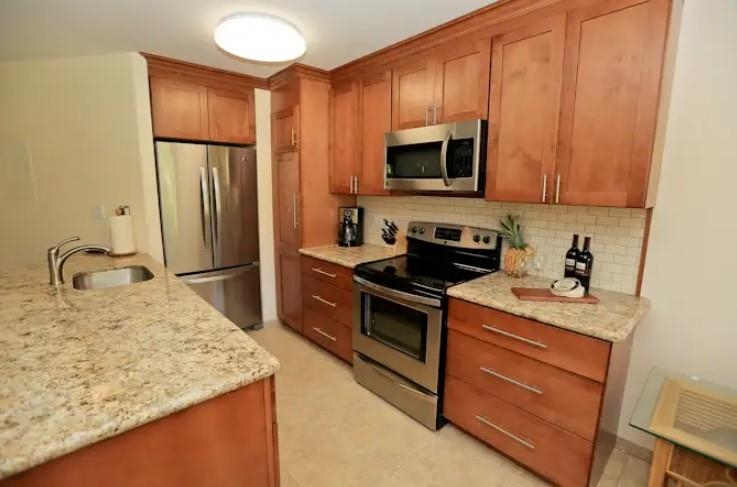 1032 South Kihei Road, Unit A103 Kihei, HI 96753 - Photo 5 of 48 a kitchen with stainless steel appliances granite countertop a sink stove and refrigerator