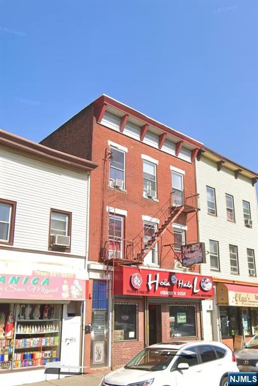 a front view of multi story building with retail shops