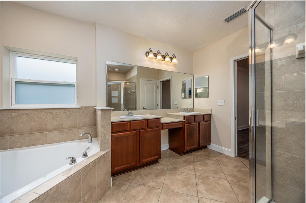8216 Northwest 54th Street Gainesville, FL 32653 - Photo 39 of 58 a bathroom with a tub a sink shower and mirror