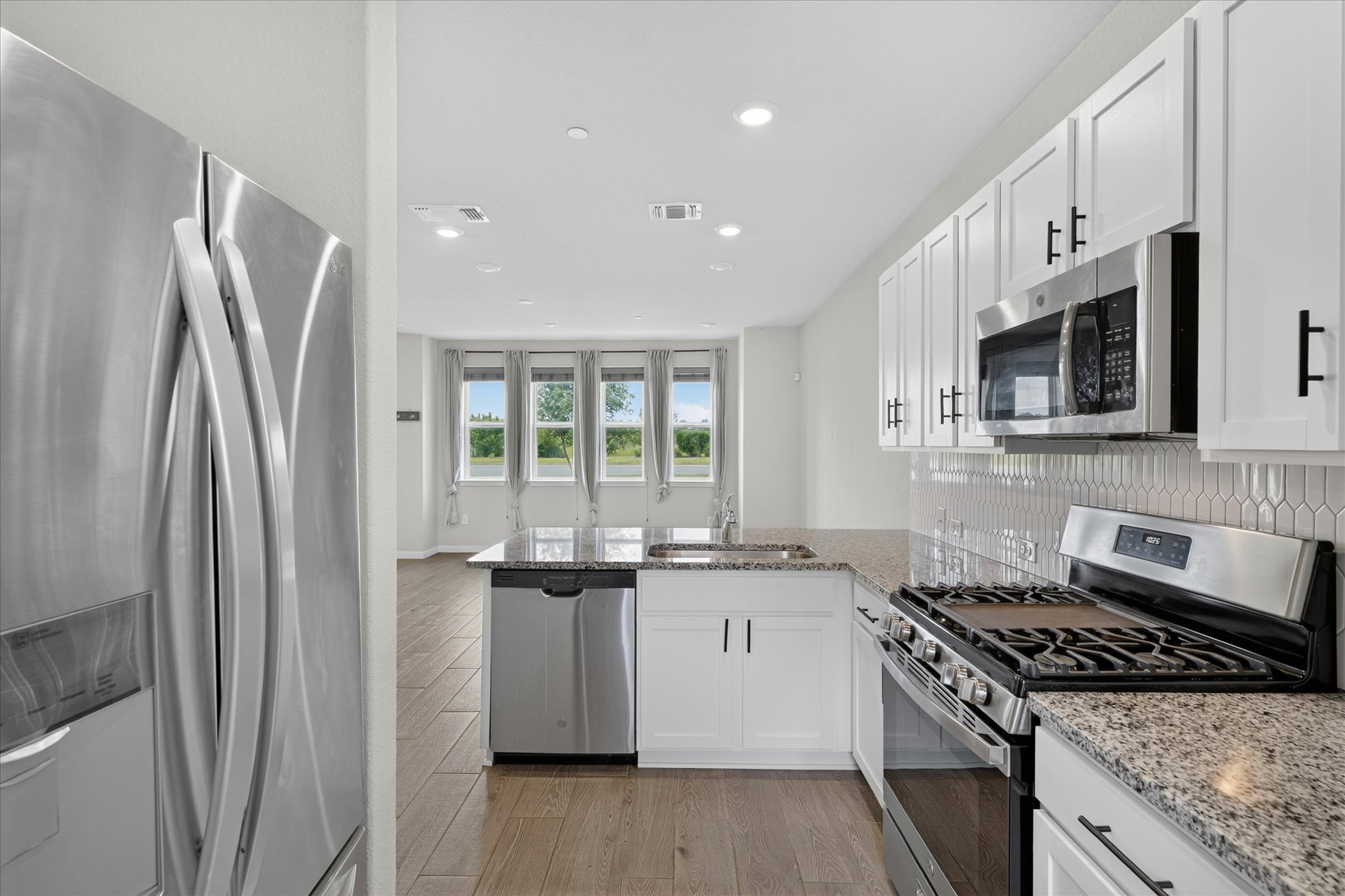 9015 Cattle Baron Path, Unit 1102 Austin, TX 78747 - Photo 7 of 25 A well-appointed kitchen showcasing contemporary appliances and sleek granite countertops.
