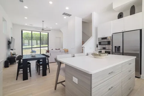 a kitchen with a stove a refrigerator and a dining table