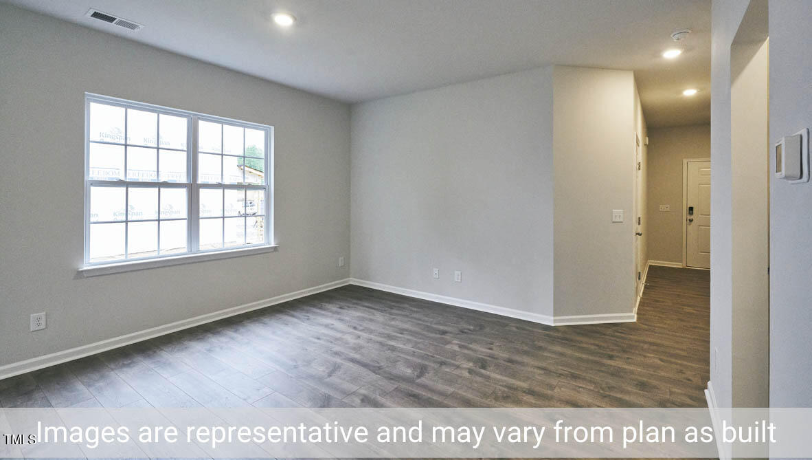 5344 Henley Ridge Drive, Unit 228 Graham, NC 27253 - Photo 11 of 30 a view of an empty room with wooden floor and a window