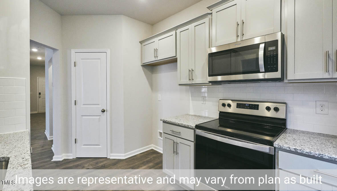 5344 Henley Ridge Drive, Unit 228 Graham, NC 27253 - Photo 16 of 30 a kitchen with stainless steel appliances white cabinets and stove