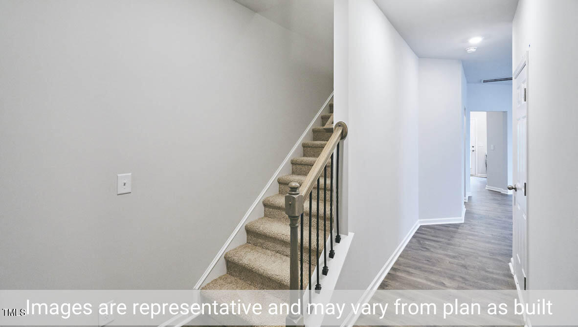 5344 Henley Ridge Drive, Unit 228 Graham, NC 27253 - Photo 2 of 30 a view of a hallway with wooden floor and staircase