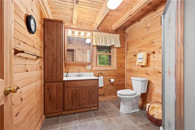 a bathroom with a granite countertop toilet a sink and a shower
