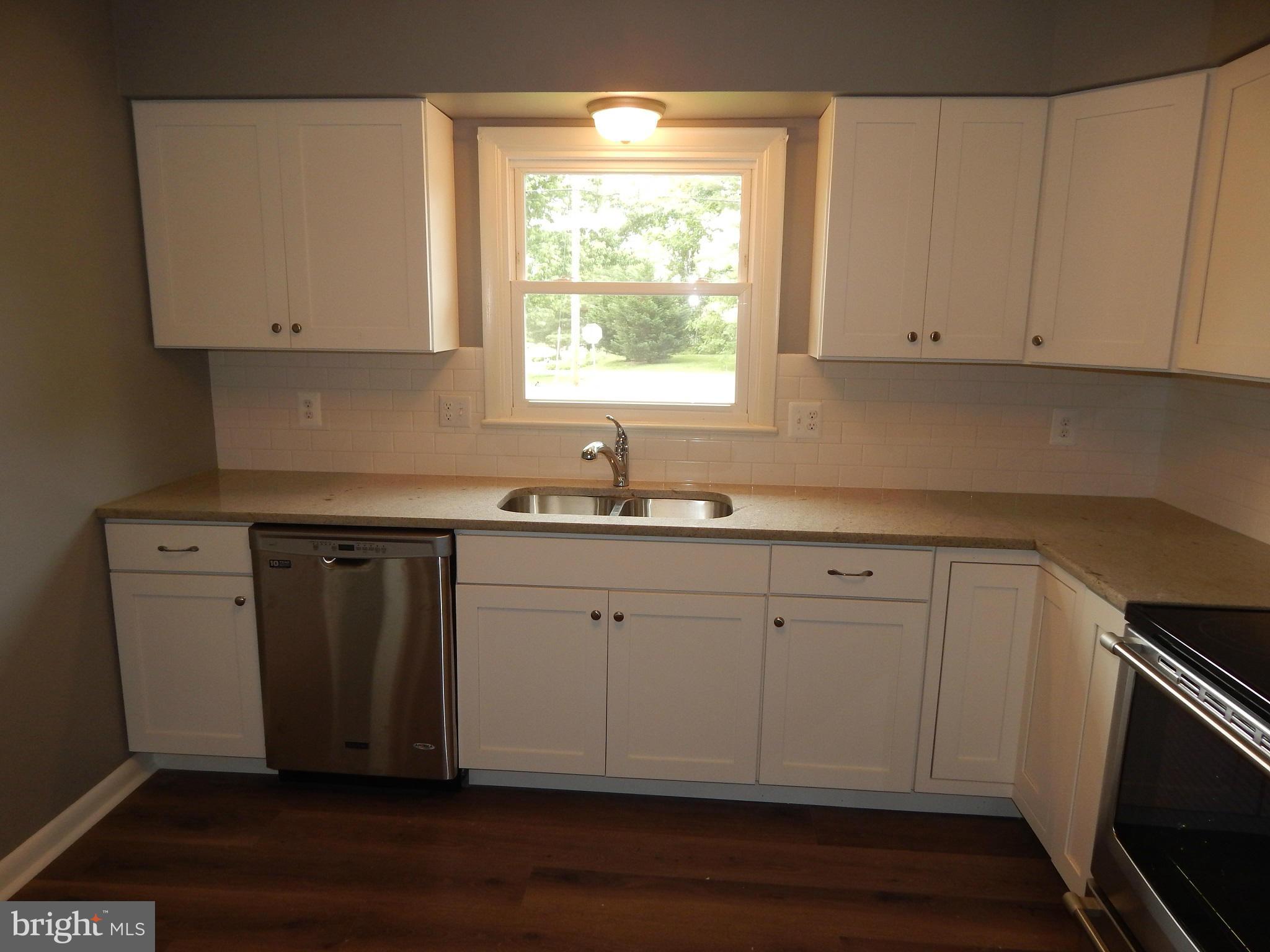 111 Calvert Towne Road Prince Frederick, MD 20678 - Photo 5 of 26 a kitchen with white cabinets white stainless steel appliances and sink