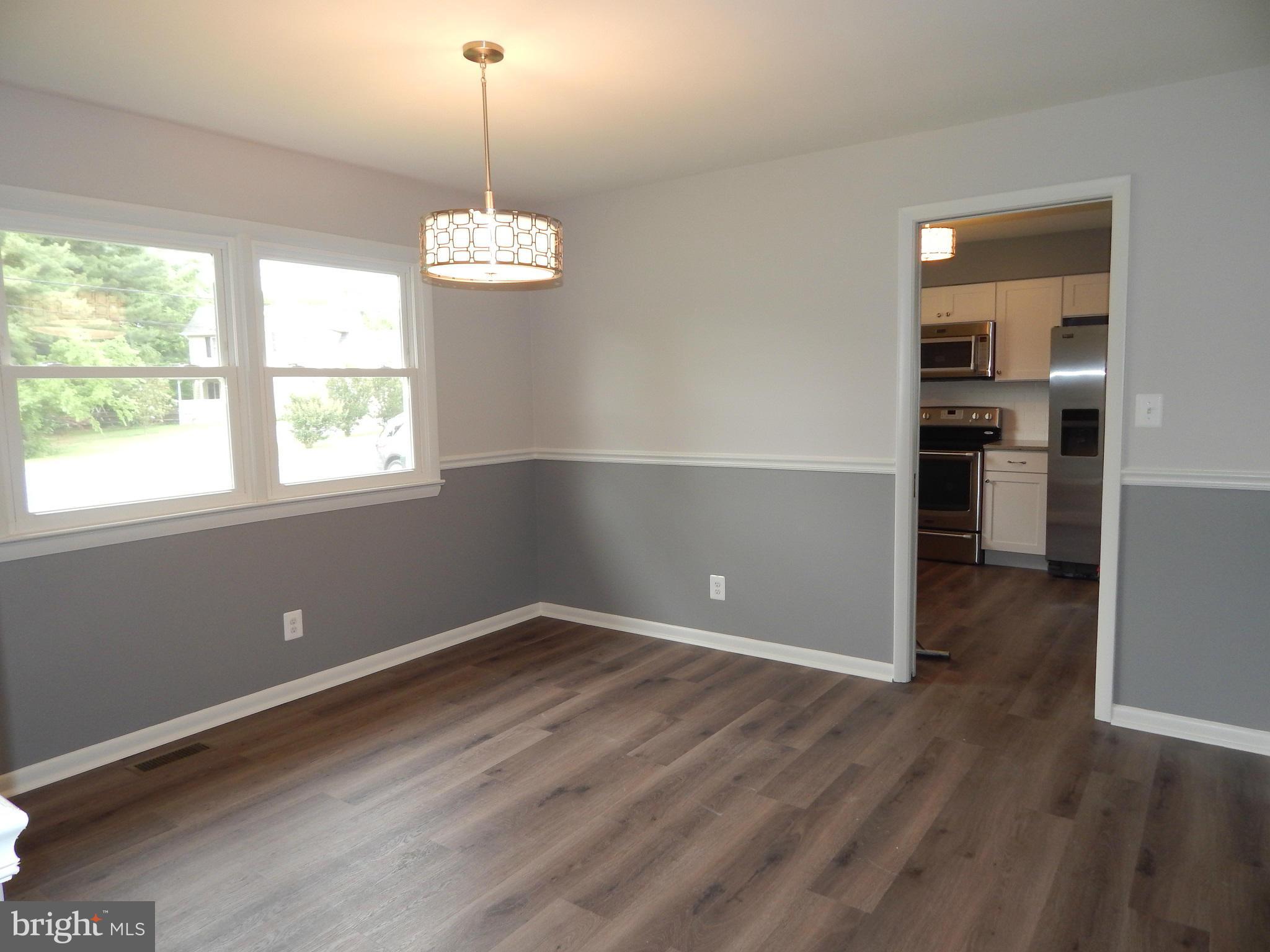 111 Calvert Towne Road Prince Frederick, MD 20678 - Photo 9 of 26 an empty room with wooden floor cabinet and windows