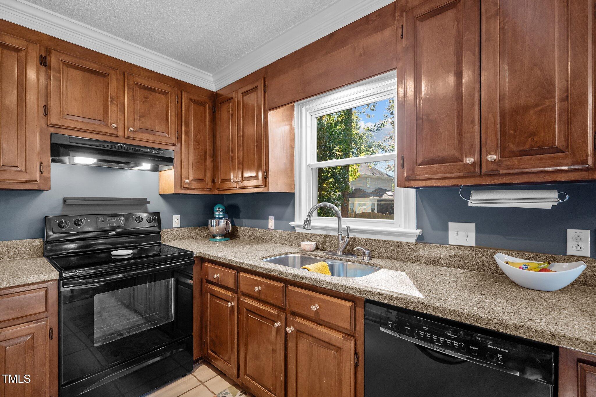 2916 Bolo Trail Raleigh, NC 27615 - Photo 12 of 43 a kitchen with stainless steel appliances granite countertop a sink a stove a microwave cabinets and a window