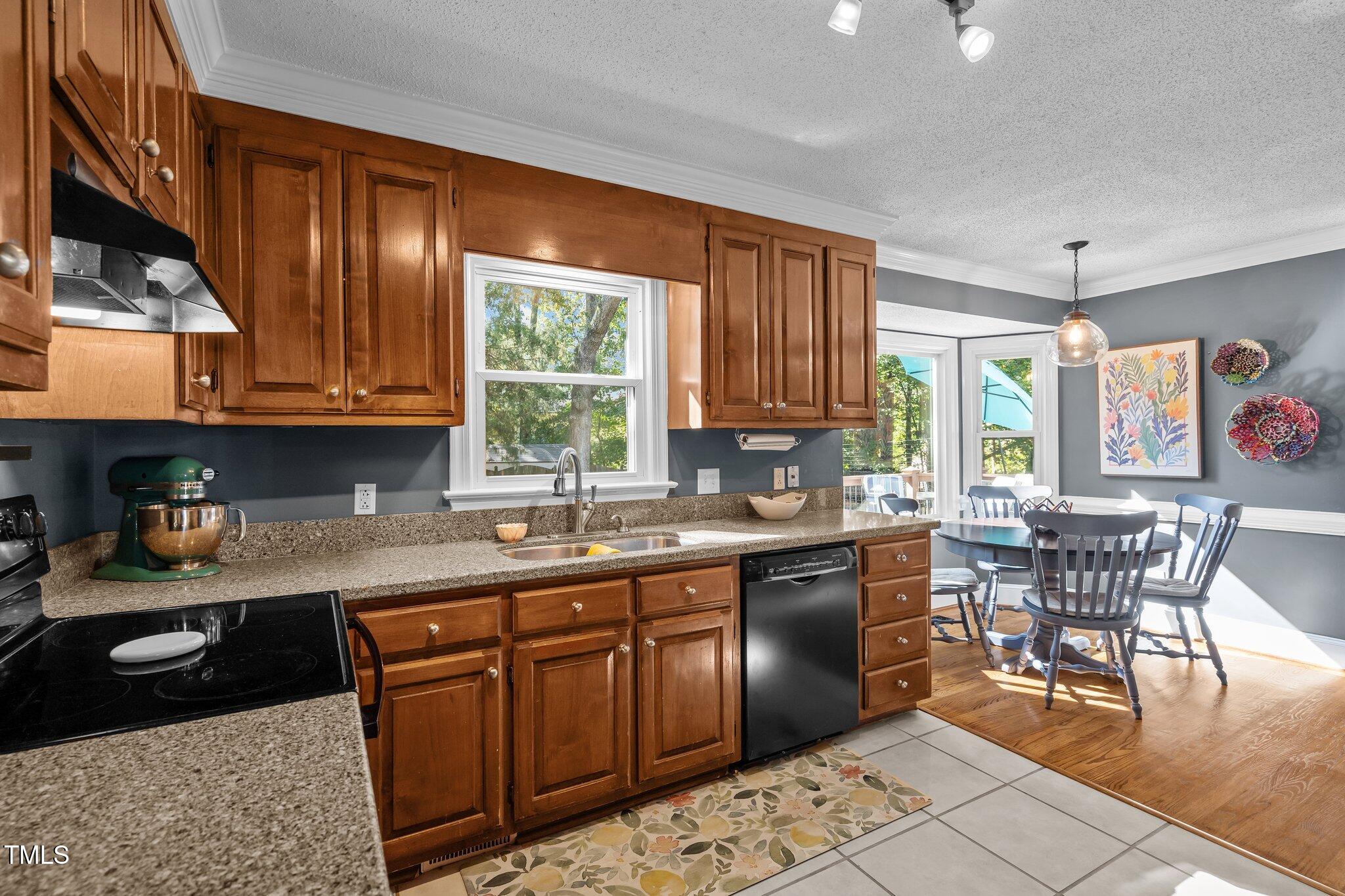 2916 Bolo Trail Raleigh, NC 27615 - Photo 13 of 43 a kitchen with stainless steel appliances granite countertop wooden cabinets a dining table and chairs
