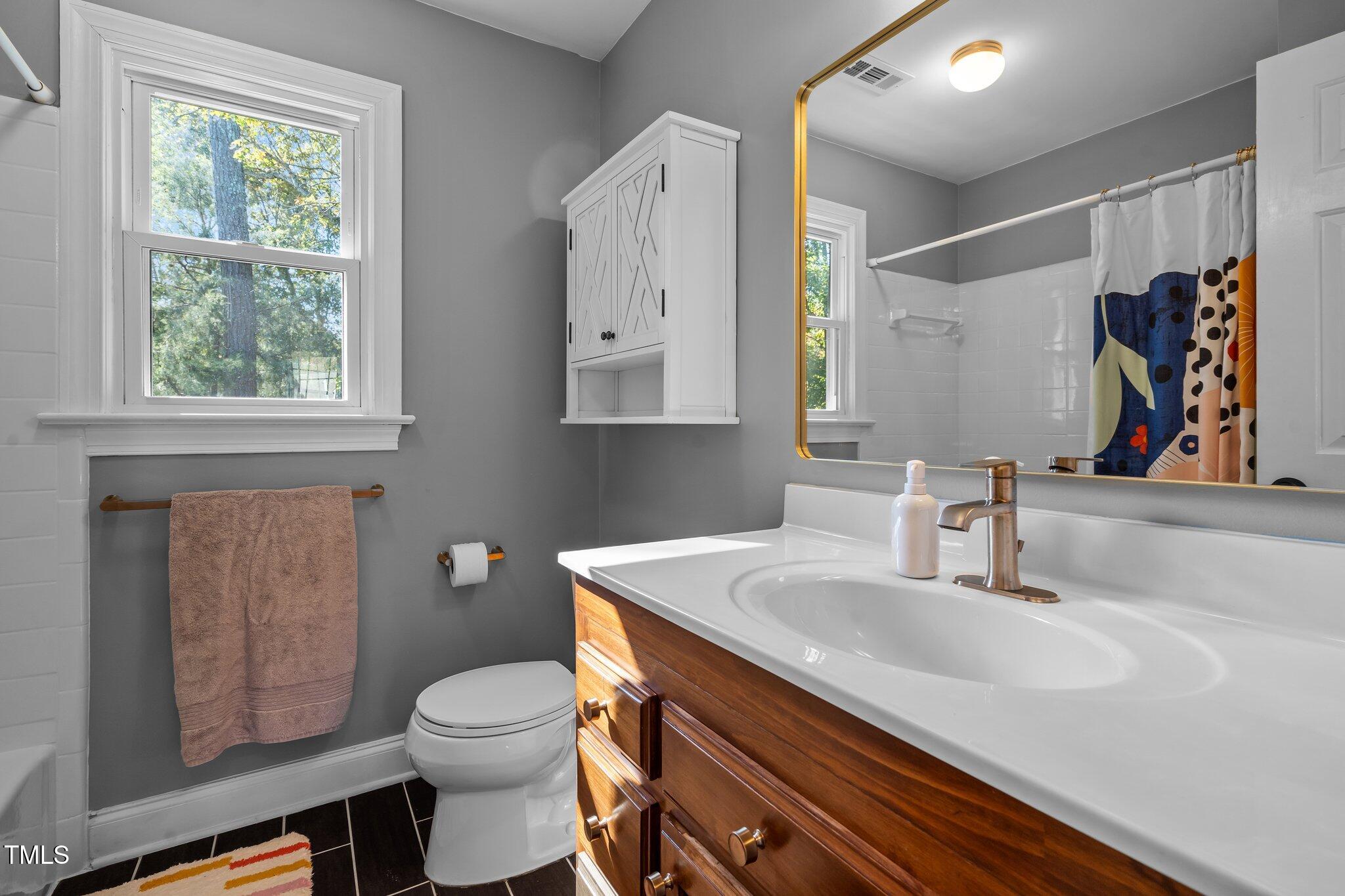 2916 Bolo Trail Raleigh, NC 27615 - Photo 21 of 43 a bathroom with a sink a toilet and a mirror