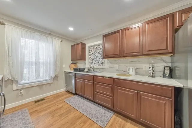 a kitchen with granite countertop wooden cabinets a sink and a window