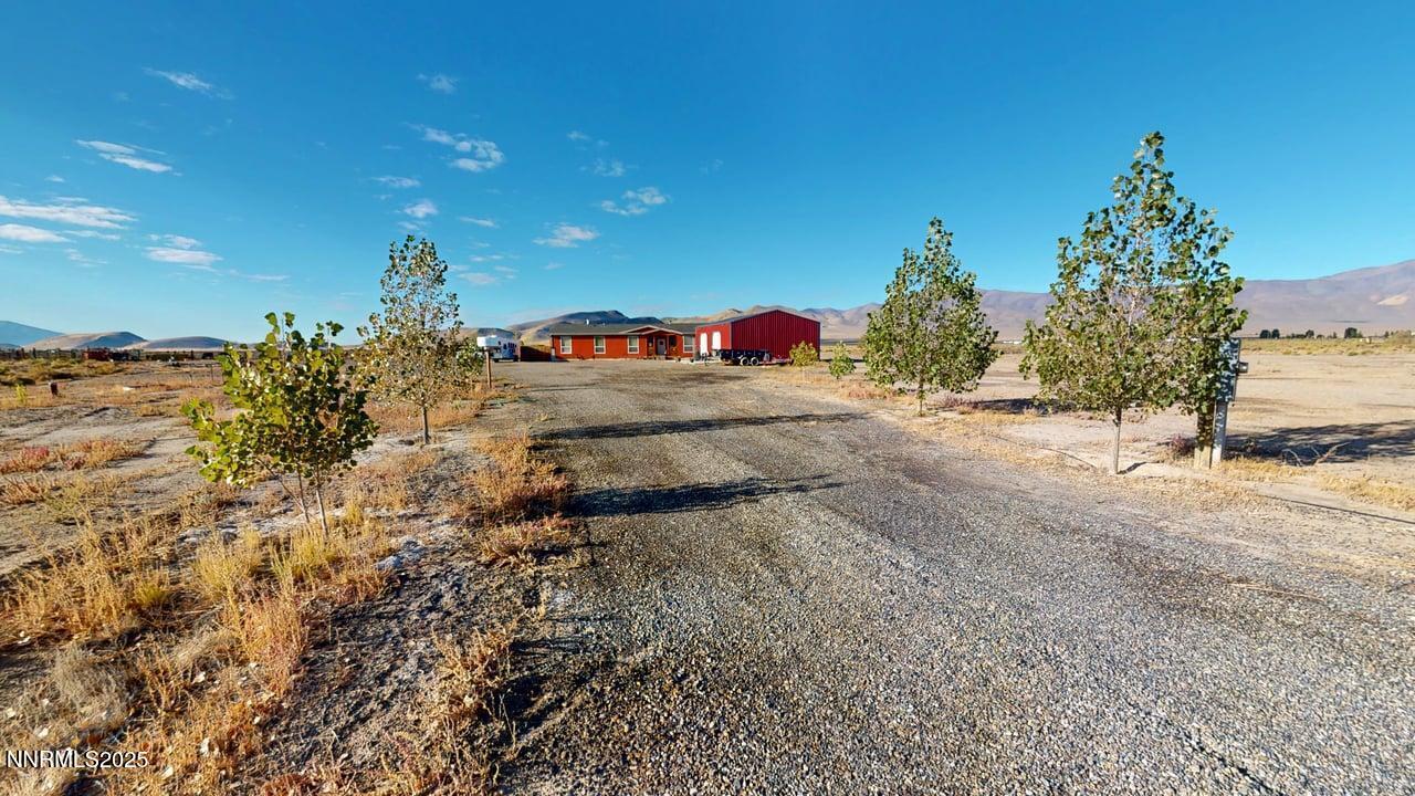 a view of a dirt road with a building in the background
