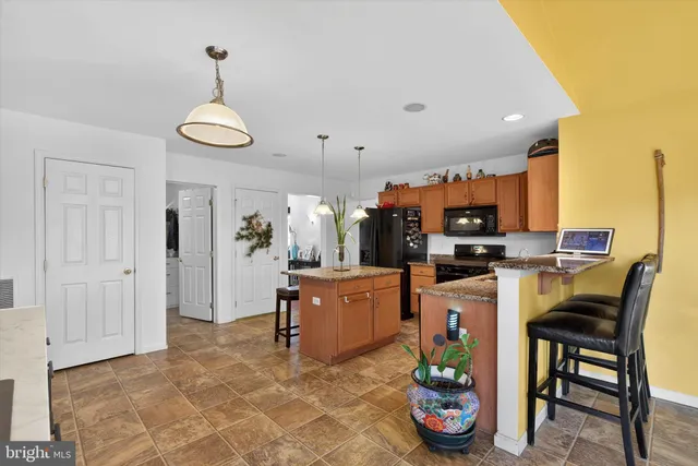 a kitchen with sink refrigerator dining table and chairs