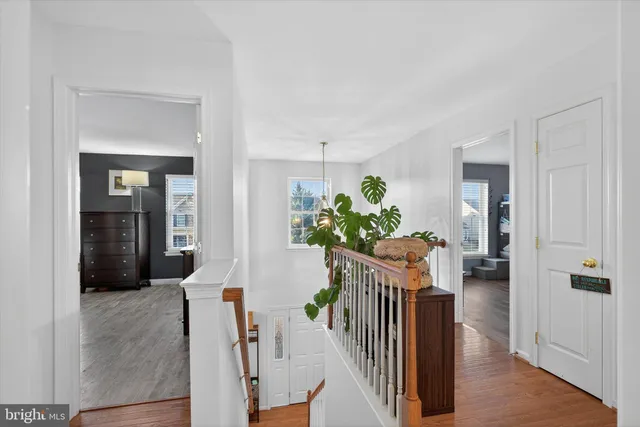 a hallway with wooden floor and stairs