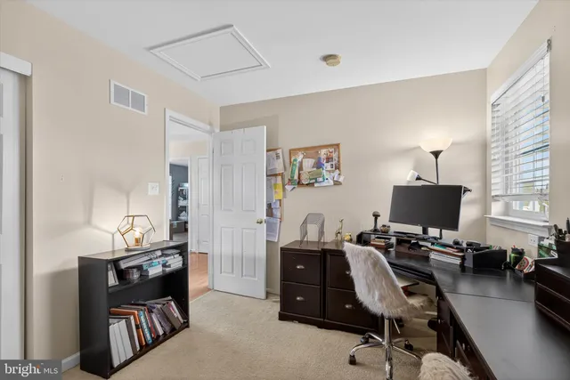 a view of a workspace with furniture and a window