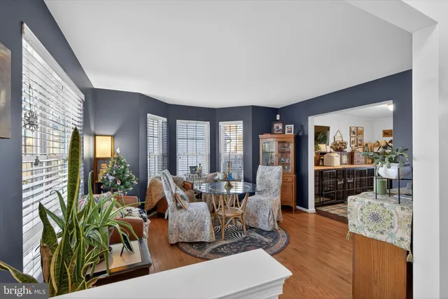 a living room with furniture floor to ceiling window and wooden floor