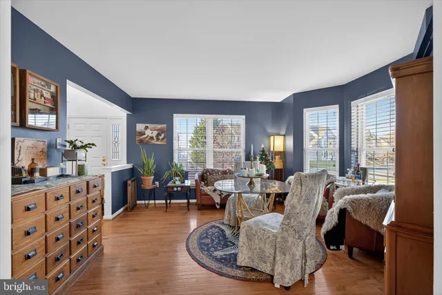 a living room with furniture large window and wooden floor