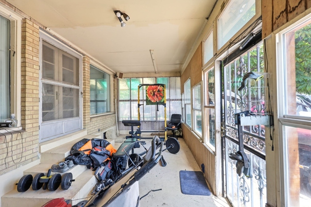 5480 South 2000th Street West Roy, UT 84067 - Photo 25 of 36 Enclosed porch featuring a brick exterior wall, multiple windows, a screened entry door, and a security door with ornate metalwork
