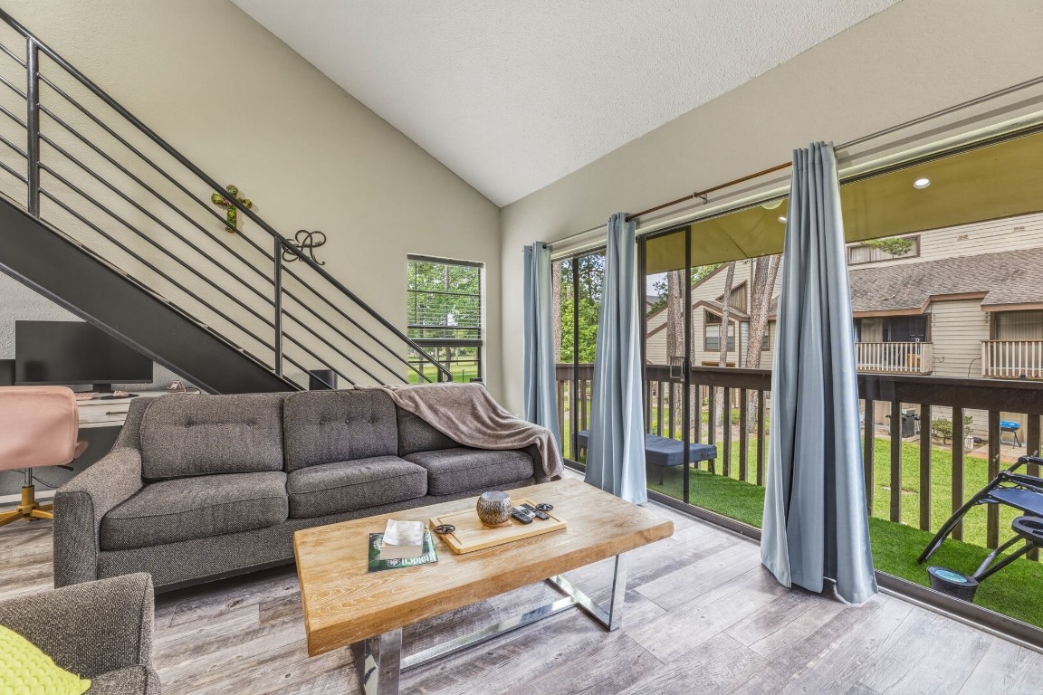 Bright open living area with extra window and huge slider opening to balcony overlooking the greenspace and the golf course with peek-a-boo views of Lake Conroe.