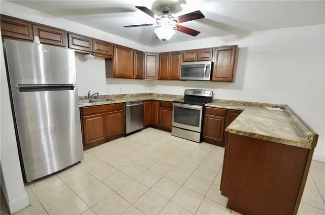 a kitchen with stainless steel appliances granite countertop a refrigerator a stove top oven a sink and dishwasher