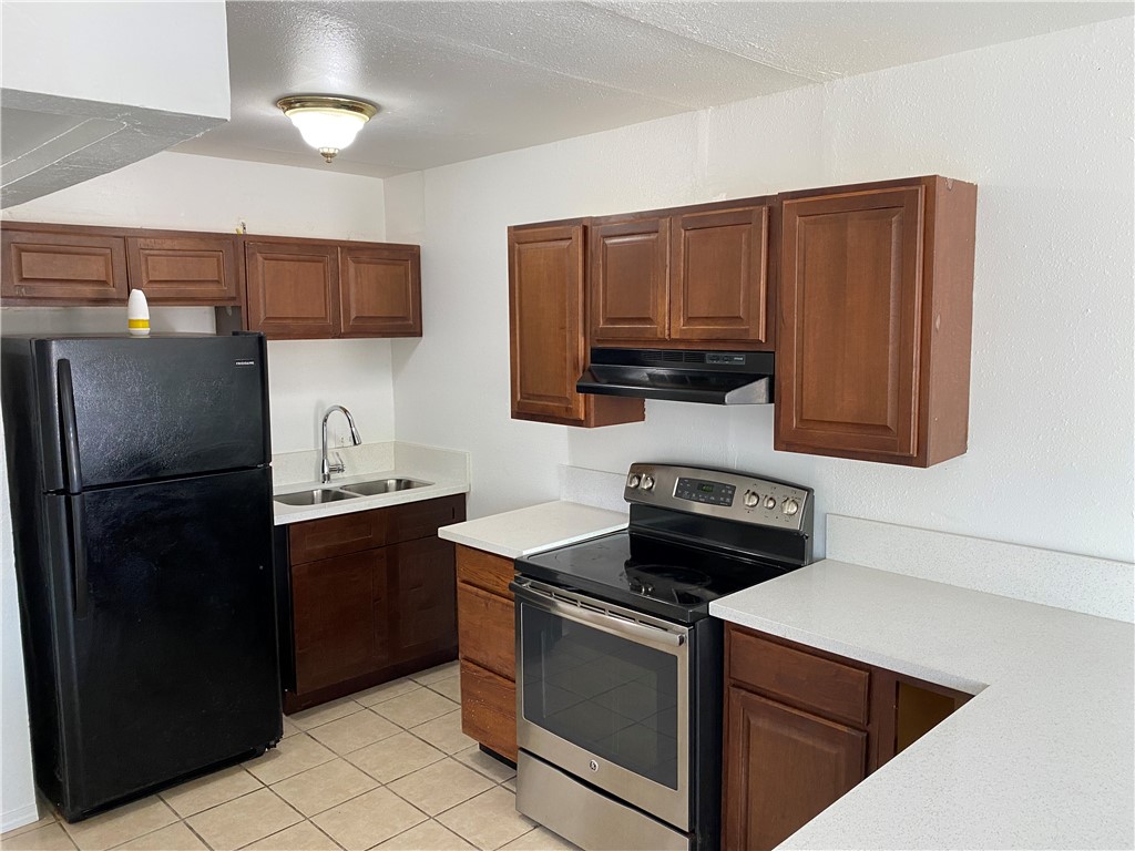 1004 Austin Street, Unit 5 Portland, TX 78374 - Photo 5 of 9 a kitchen with stainless steel appliances granite countertop a sink stove and refrigerator