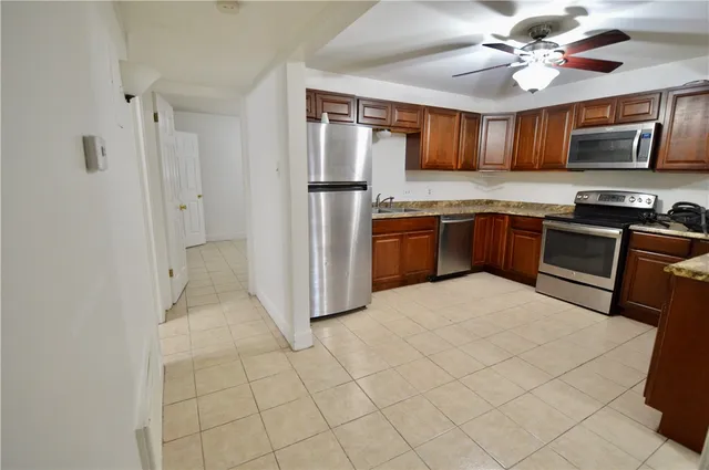 a kitchen with stainless steel appliances granite countertop a refrigerator a stove top oven a sink and dishwasher