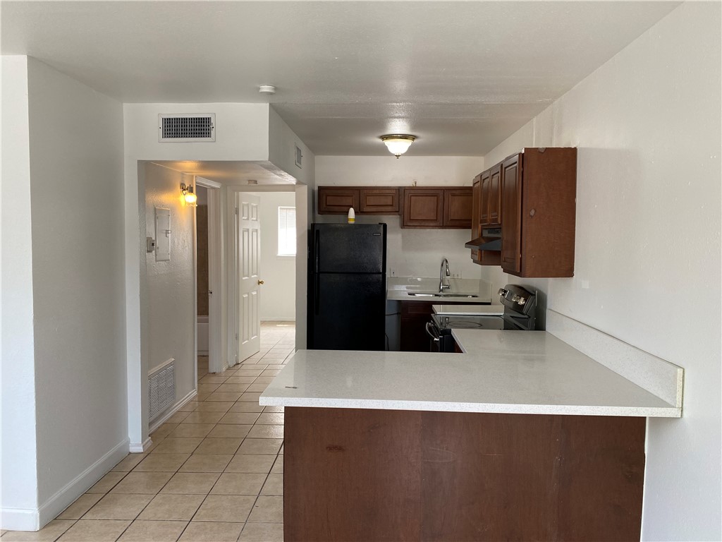 1004 Austin Street, Unit 5 Portland, TX 78374 - Photo 6 of 9 a kitchen with stainless steel appliances a refrigerator and a counter top space
