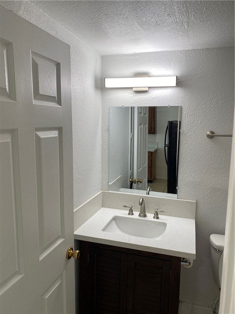 1004 Austin Street, Unit 5 Portland, TX 78374 - Photo 7 of 9 a bathroom with a sink and a mirror