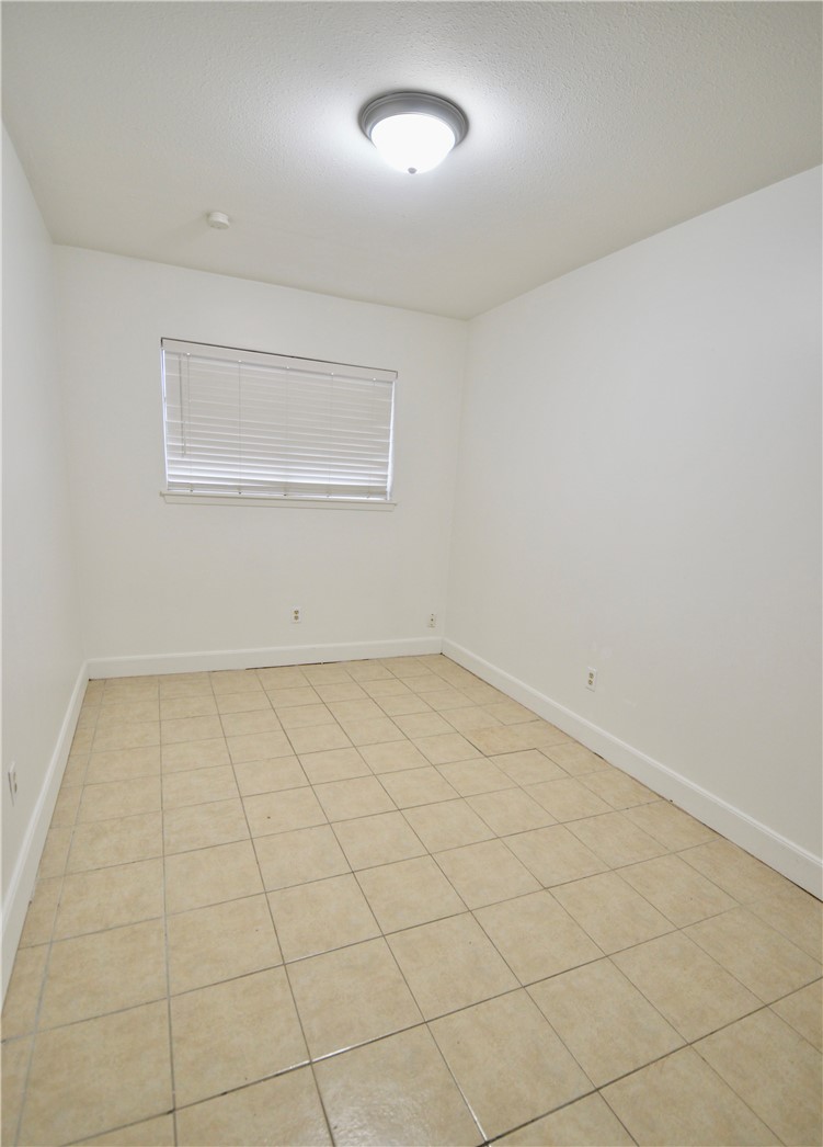 1004 Austin Street, Unit 3 Portland, TX 78374 - Photo 10 of 12 an empty room with a bench