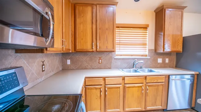 a kitchen with stainless steel appliances granite countertop a sink and a cabinets